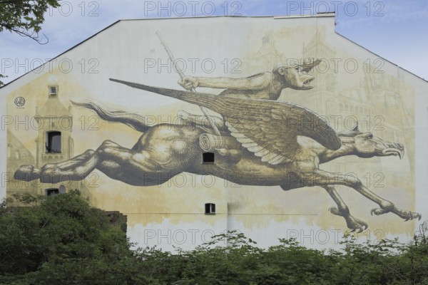 Mural Journey by Wild Drawing WD 2016, Meeting of Styles, MOS, street art, graffiti, horse with wing and beak and monkey as rider, mythical creature, equestrian figure, traveling, gallop, speed, flying, dragon, monkey figure, chimpanzee, fantasy, house facade, tree trunk, Mainz-Kastel, Wiesbaden, Taunus, Hesse, Germany