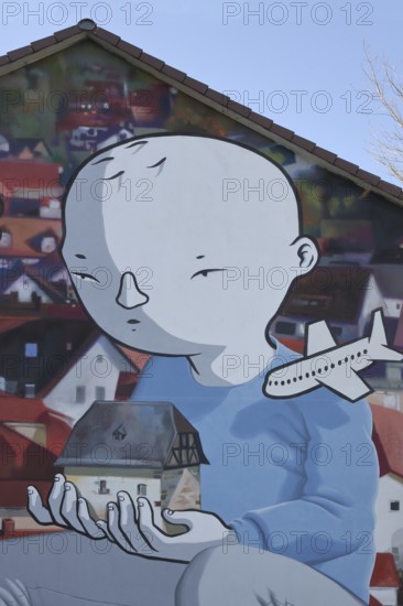 Mural by CASE MacAclaim and Millo, street art, graffiti, child carrying house in hands, illustration, comic, airplane, carrying, Andreas von Chrzanowski, Francesco Camillo Giorgino, Bad Vilbel, Wetterau, Hesse, Germany