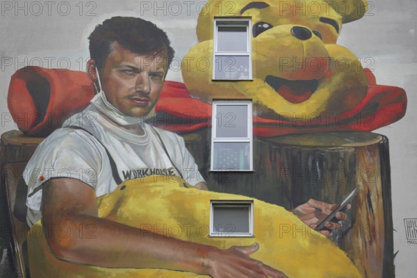 Mural Waldsterben by CASE MaClaim 2024, man with yellow plush toy, bear figure, street art, photorealistic graffiti, house facade, symbol, Bad Vilbel, Wetterau, Hesse, Germany