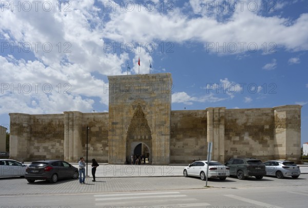 Historic fortress with an open gate, cars and passers-by in the foreground, Sultanhani caravanserai, on the former Silk Road, museum, Sultanhani Kervansaray, Sultanhani, Aksaray province, Turkey