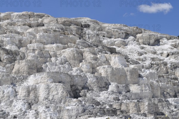 White, layered volcanic deposits under blue sky, Yellowstone National Park, Wyoming, USA
