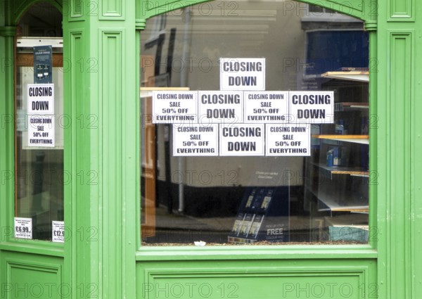 Shop window signs with empty shelves closing down sale, Beccles, Suffolk, England, UK