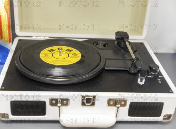 Vintage portable record player with 45 RPM vinyl record on turntable with MGM label
