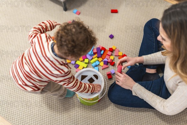 Parent and toddler bonding on the living room floor, engaging in educational play with a shape sorter and building blocks, fostering early childhood development