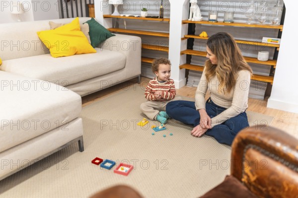 Mother and toddler sitting on the floor in their living room, engaging in educational play with colorful toys, fostering early childhood development and bonding through shared activities
