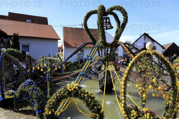 Easter fountain in Bieberbach, supposedly the largest Easter fountain in the world, Egloffstein market, Franconian Switzerland, Forchheim district, Upper Franconia, Bavaria, Germany, fountains richly decorated with colorful garlands, spring-like atmosphere in the village environment