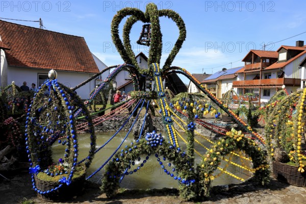 Easter fountain in Bieberbach, supposedly the largest Easter fountain in the world, Egloffstein market, Franconian Switzerland, Forchheim district, Upper Franconia, Bavaria, Germany, decorated Easter fountain with garlands, festive decoration and traditional village environment