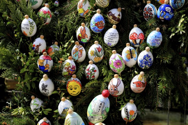 Detail, eggs painted by children, comic characters, Easter fountain in Heiligenstadt, Franconian Switzerland, Bamberg district, Upper Franconia, Bavaria, Germany, colorful, painted Easter eggs hanging on a tree, festive and happy atmosphere in nature