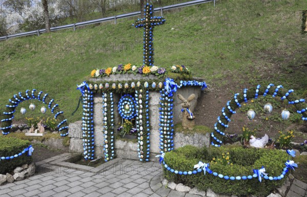 Easter fountain in Tiefenpölz, Markt Heiligenstadt, Franconian Switzerland, Bamberg district, Upper Franconia, Bavaria, Germany, richly decorated Easter fountain with flowers and blue eggs
