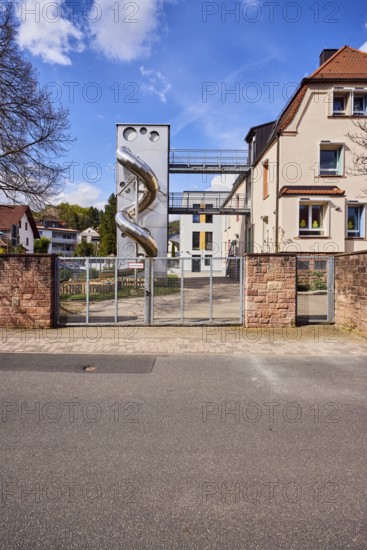 Catholic kindergarten St. Michael, slide, play equipment, commercial building, modern architecture, sandstone wall, wooden fence, metal gate, bare winter trees, blue sky, cumulus clouds, cirrus clouds, Untere Forststraße, Waldaschaff, Lower Franconia, Aschaffenburg district, Bavaria, Germany