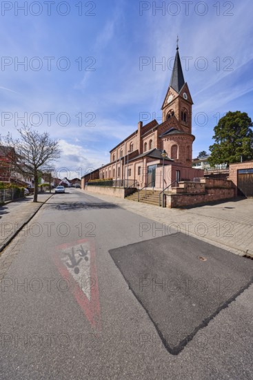 St. Michael church, parish church, neo-Romanesque style, sidewalk, roadway, road marking Attention children, parking strips with car, trees, blue sky, cumulus clouds, cirrus clouds, Kirchstraße, Waldaschaff, Lower Franconia, Aschaffenburg district, Bavaria, Germany