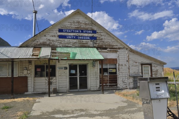 Close-up of a white wooden building, Stratton's Store, with signs and weathered paint, Unity, Oregon, USA