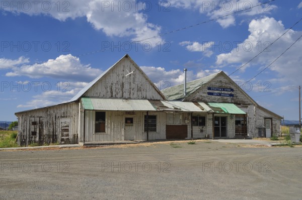Two connected weathered buildings, Stratton's Store store, under blue sky with scattered clouds, Unity, Oregon, USA