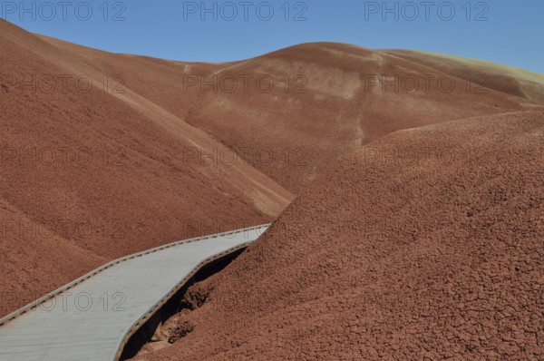 Wooden trail through red, hilly landscape, John Day Fossil Beds National Monument, Painted Hills Unit, Oregon, USA