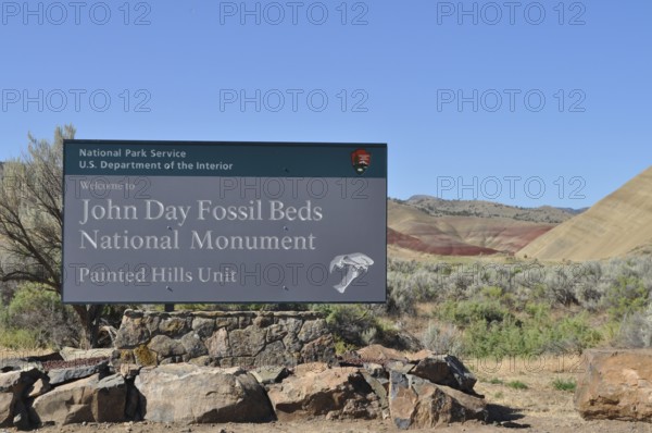 John Day Fossil Beds Painted Hills Welcome Sign with Blue Sky and Natural Backdrop, John Day Fossil Beds National Monument, Painted Hills Unit, Oregon, USA