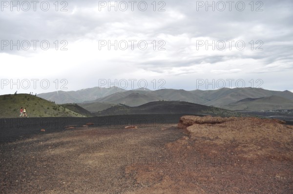 Red lava rock and hills under dramatic sky, Craters of the Moon National Monument, Idaho, USA
