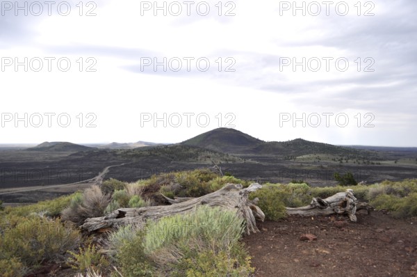 Barren lava landscape with hills under cloudy sky, Craters of the Moon National Monument, Idaho, USA