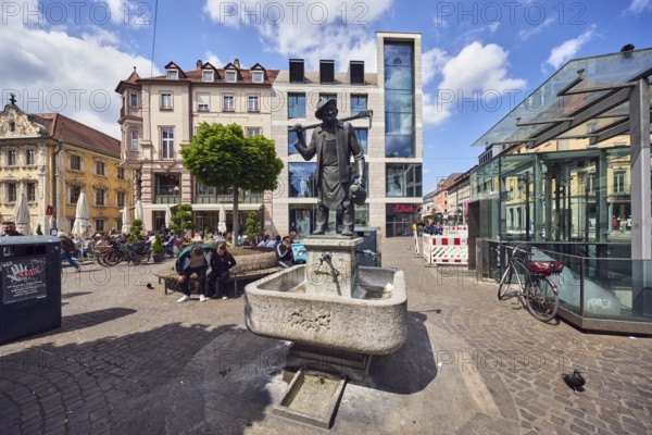 Häckerbrunnen, fountain with bronze sculpture, sculptor Richard Rother, square, general architecture, commercial building, modern architecture, gastronomy, outdoor area, benches, pedestrian zone, tree, pedestrians and seated people as a secondary motif, blue sky, cumulus clouds, intersection of marketplace with Schönbornstraße, Würzburg, Lower Franconia, district-free city, Bavaria, Germany