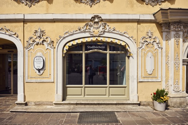 Public library Max-Heim-Bücherei, Falkenhaus, Haus zum Falken, city center, historic building, rococo style, façade with window and stucco decoration, shop window, flower pot with plants, sunny, market square, Würzburg, Lower Franconia, district-free city, Bavaria, Germany
