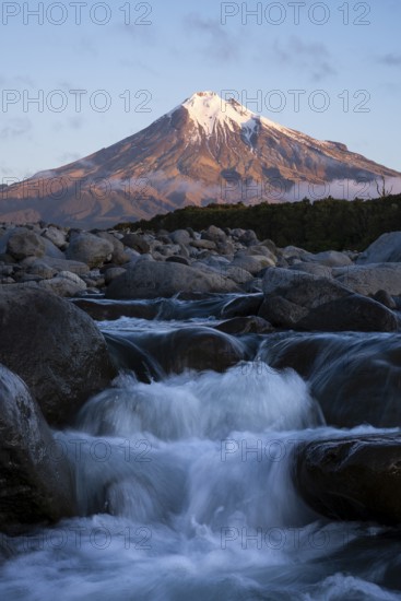 Mount Taranaki in the evening at sunset, in the foreground Stony River (Hangatahua River), Egmont National Park, Taranaki Region, North Island, New Zealand