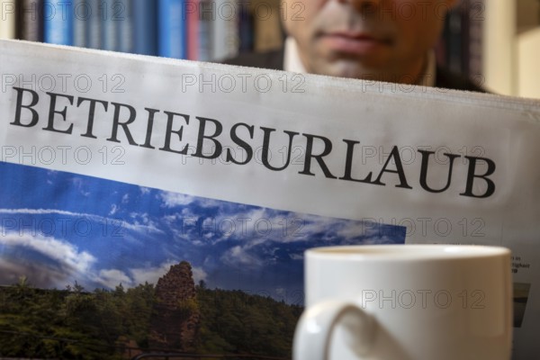 Man reads a (symbolic) newspaper with the headline BUSINESS HOLIDAY