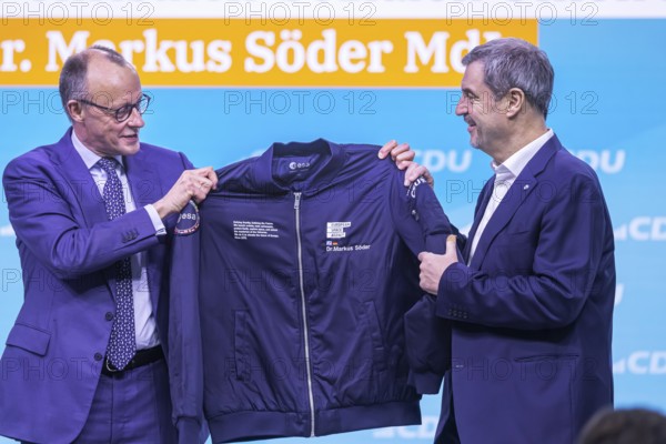 38th Federal Party Congress of the CDU of Germany in Stuttgart. Greetings from Markus Söder, party leader of the sister party CSU and Minister-President of the Free State of Bavaria. Federal Chancellor Friedrich Merz hands over an esa astronaut jacket to the guest speaker because of Söder's space visions. He is also an avowed fan of the cult film Star Trek. Stuttgart, Baden-Württemberg, Germany