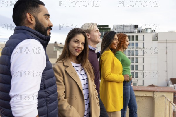 A cheerful group of friends enjoys a rooftop gathering, creating joyful memories with smiles and camaraderie Perfect for themes of friendship, celebration, and leisure