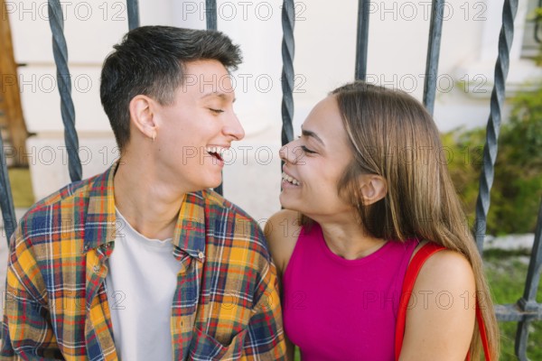 A happy lesbian couple shares a joyful moment in an urban setting, highlighting love and connection. They embody diversity and the spirit of LGBTQIA+ pride and equality