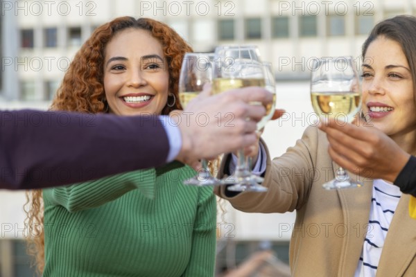 A cheerful group of friends clink glasses in a joyful celebration, capturing the essence of camaraderie and happiness at a lively party gathering