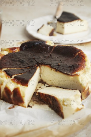 Elegant minimalist photo featuring a slice of San Sebastian cheesecake delicately placed on a rustic table, highlighting its burnt top and creamy texture