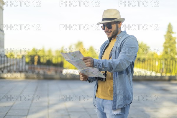 A Latino transgender man, wearing casual denim and a straw hat, navigates a city with a map in hand He exudes confidence and pride, symbolizing exploration and diversity