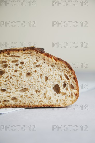 Close-up detail of a freshly cut slice of sourdough bread, showcasing its airy texture and crusty edge