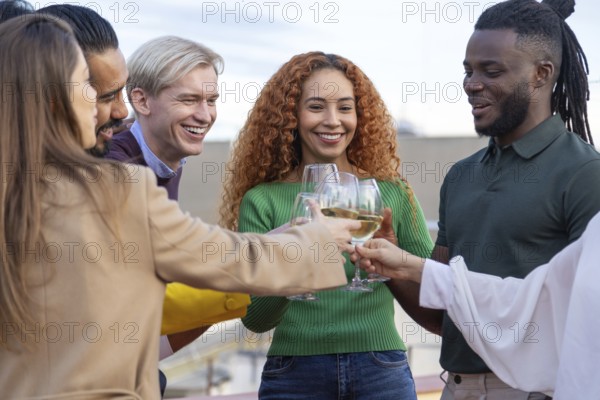 A joyful group of friends gather outdoors, sharing laughter and clinking glasses in celebration They smile warmly, capturing the vibrant energy of a festive occasion