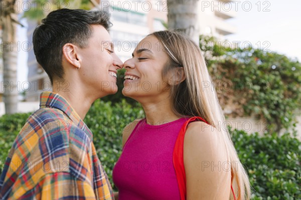 A happy lesbian couple shares a joyful moment, embracing their love and diversity outdoors. Their expressions reflect the essence of pride, equality, and inclusivity
