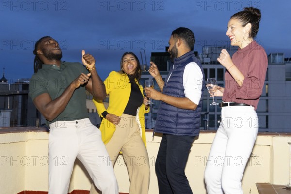 A lively group of friends celebrating at a rooftop party in the city They are dancing, laughing, and enjoying the night with drinks, capturing the spirit of togetherness
