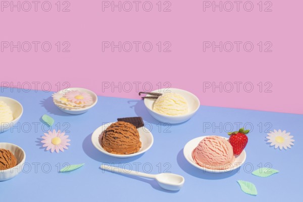 Vibrant image featuring bowls of various ice cream flavors on a dual-tone pink and blue background. Each bowl is embellished with decorative elements like flowers and strawberries