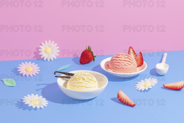 Vanilla and strawberry ice cream in white bowls amid colorful paper flowers on a pink and blue background, accented with fresh strawberries and decorative elements