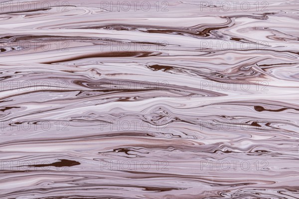 A mesmerizing marbled texture featuring swirling patterns of brown and pink acrylic paint hues. The fluid dynamics create a captivating abstract design, perfect for backgrounds