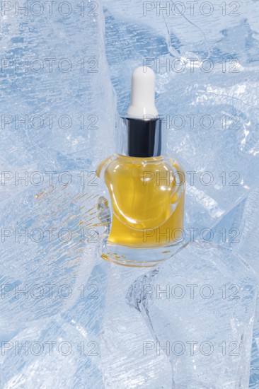 A single serum bottle filled with golden liquid, encased gracefully in cracked, transparent ice, presenting a luxurious and cool visual appeal