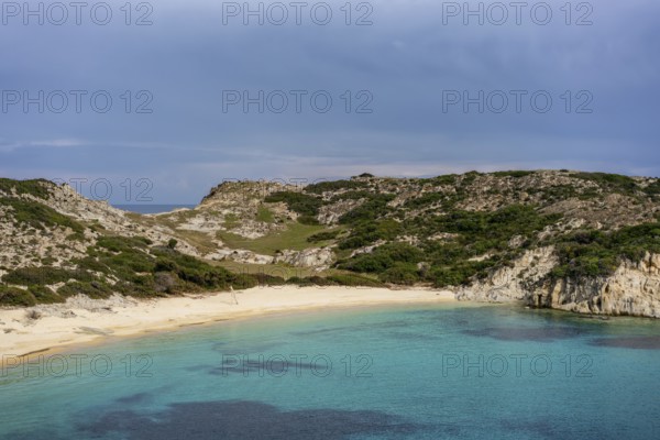 Kalamitsi Beach in Greece offers a serene setting with turquoise waters, golden sand, and a rugged, natural landscape. A hidden gem surrounded by lush greenery and rocky hills