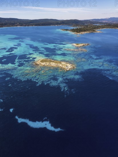 Aerial view of Diaporos Island with vibrant turquoise waters and rocky formations, surrounded by the deep blue sea. A peaceful and remote Mediterranean escape, ideal for nature lovers
