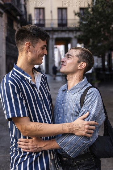 Gay couple embraces on the charming streets of Madrid, sharing a moment of affection. Capturing the vibrant spirit and diversity of the city's LGBTQIA+ community