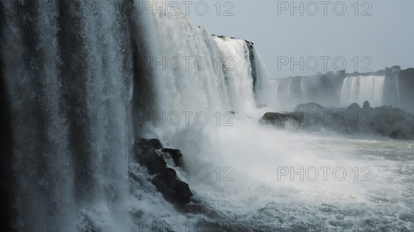 Stunning capture of the powerful Iguazu Falls surrounded by mist and plunging into the river at the border of Argentina and Brazil