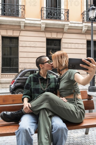 Colombian lesbian couple captures a loving kiss on a city bench, showcasing affection and identity. A celebration of LGBTQIA+ love, diversity, and acceptance