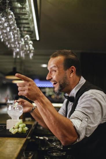 Professional bartender crafting cocktails in a chic bar. The atmosphere is lively and sophisticated, highlighted by elegant glassware and refined decor, capturing the art of mixology