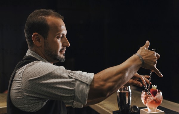 A skilled bartender expertly prepares a colorful cocktail at a lively bar, showcasing precision and creativity in mixology. The ambient lighting sets a vibrant mood