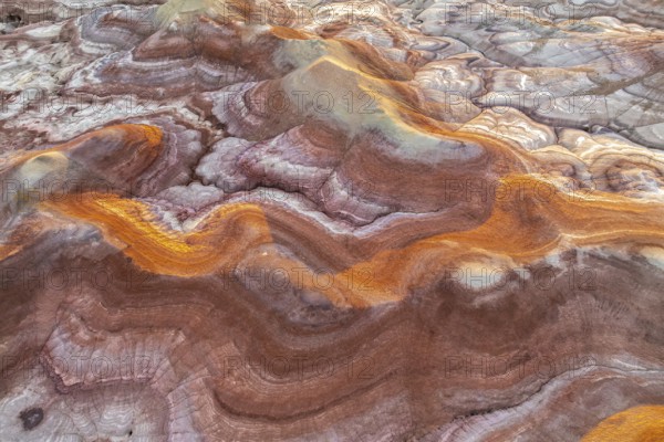 Capture of Utah's bentonite formations, showcasing swirling patterns and vibrant hues of gold and pink. Nature's palette highlights geological wonders across desert terrain