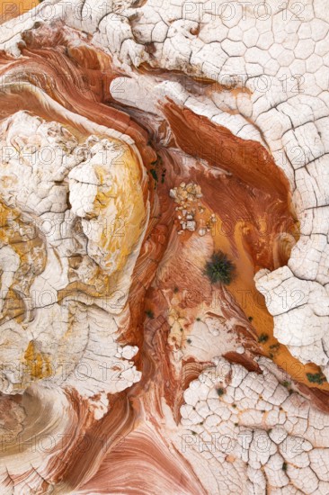 This striking aerial image captures the complex patterns of red and white rock formations. The textures and curves create an abstract natural landscape