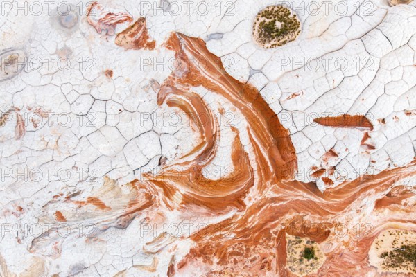 This stunning aerial photograph captures the intricate details of abstract red and white rock formations, showcasing a naturally artistic and textured landscape