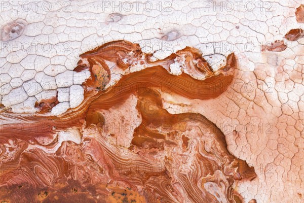 Vibrant and textured aerial view of abstract red and white rock formations, showcasing intricate layers and cracked surfaces